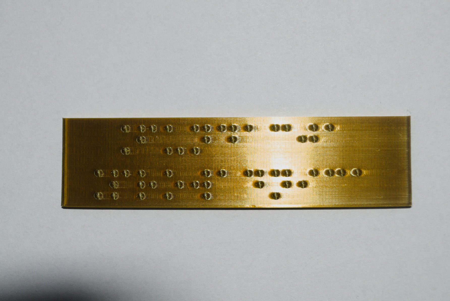 Tabliczka z PLA domieszkowanego mosiądzem, z brajlowskim napisem "Fundacja Prowadnica"