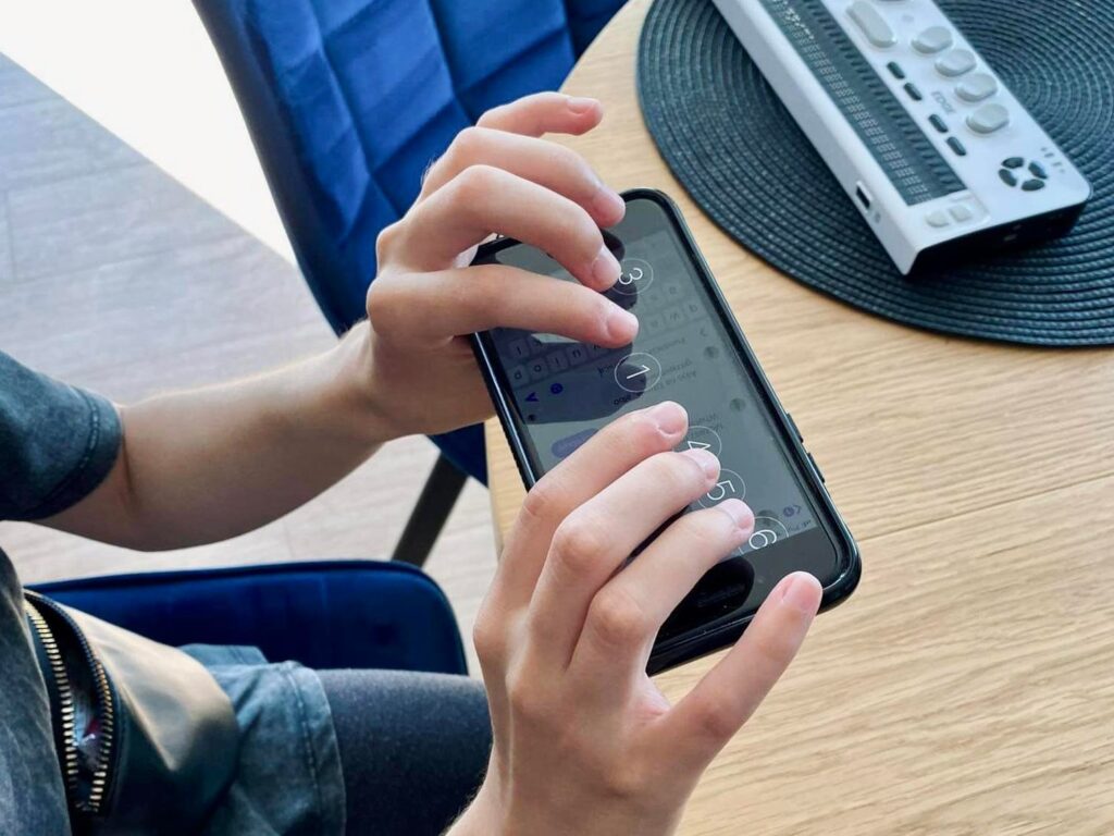 Maja pisze, korzystając z ekranu Brajla