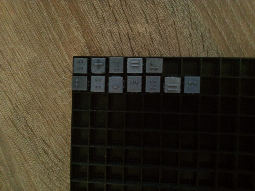 Na planszy kubarytmów ułożone równanie wykorzystujące cyfry, zmienne i operatory matematyczne