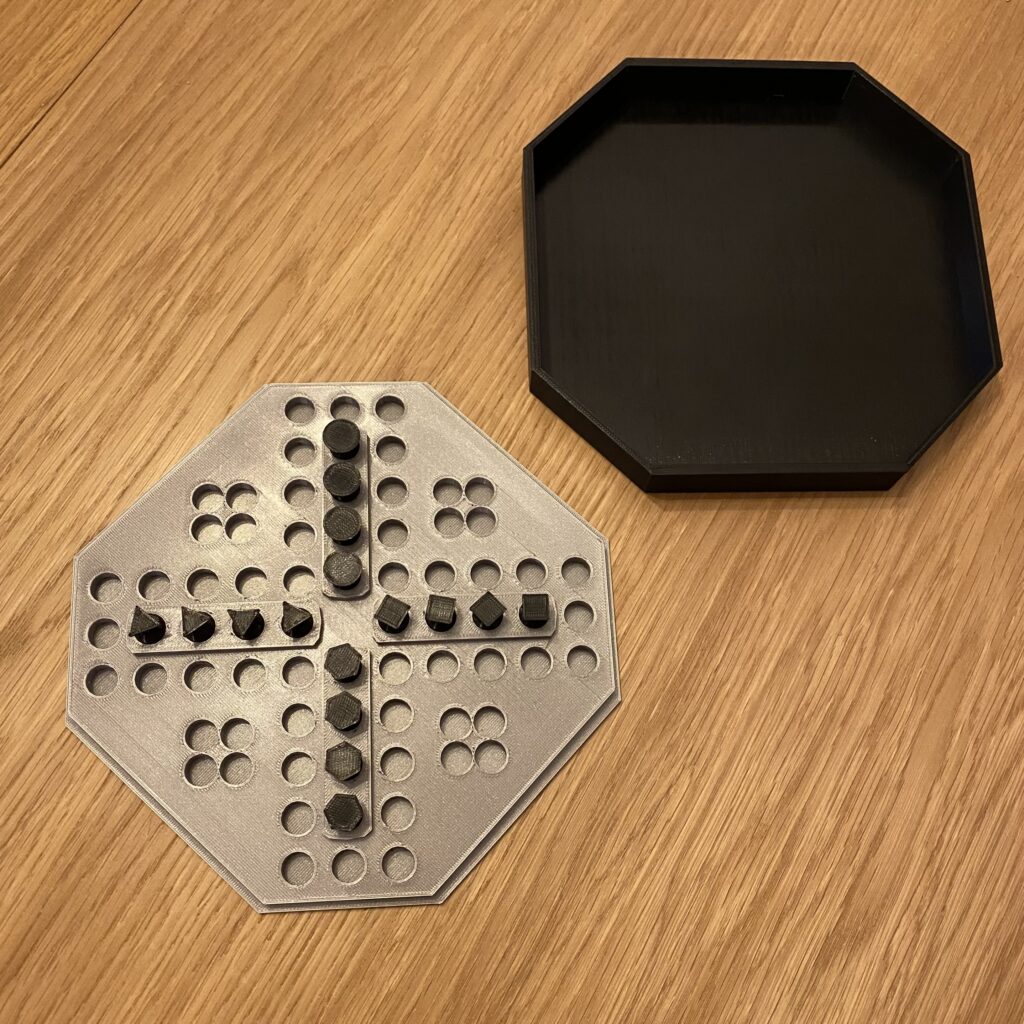 Chińczyk: pionki są ustawione na polach startowych. Poszczególne pionki są identyfikowane przez kształt główki: koło, trójkąt, kwadrat lub sześciokąt.