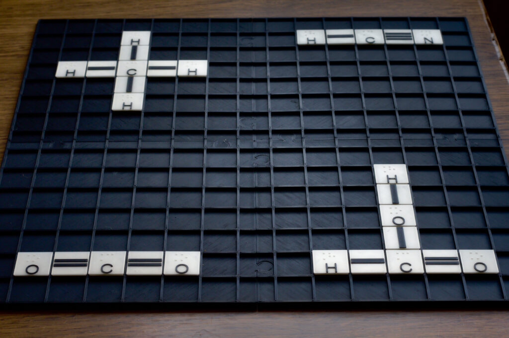 Na tablicy ułożone są cztery przykładowe wzory strukturalne. Kolejnymi ćwiartkami układu współrzędnych są to: cyjanowodór (HCN), metan (CH4), dwutlenek węgla (CO2) i kwas mrówkowy (HCOOH).