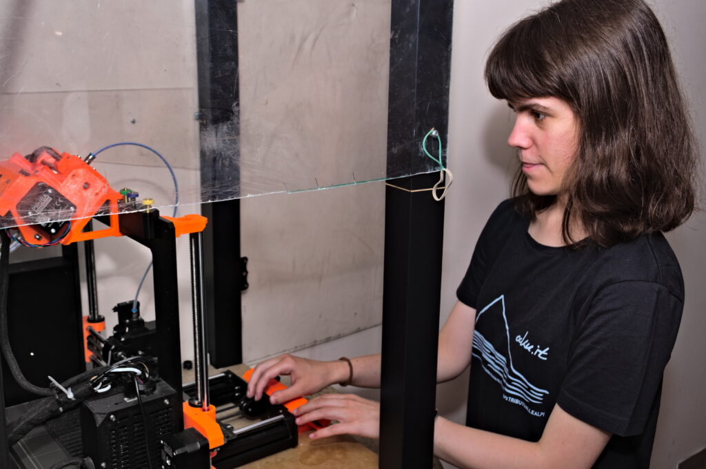 Maja stoi koło drukarki 3d