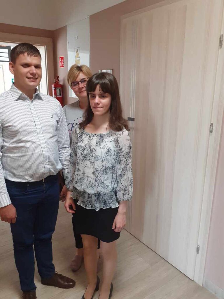 Dawid i Maja wraz z przedstawicielką Urzędu Gminy w Trzcianie. W tle widać tabliczkę na drzwiach wykonaną przez Fundację Prowadnica.