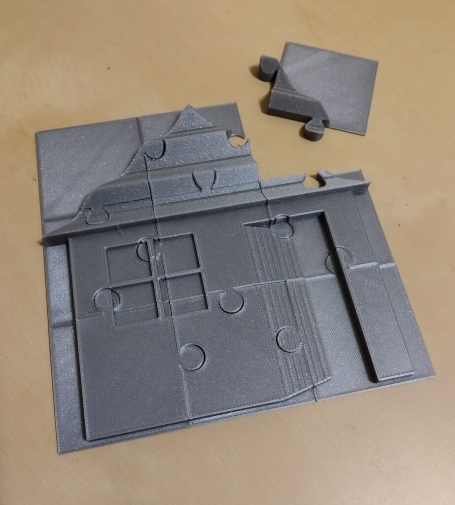 Puzzle ułożone w domek z jednym wyjętym puzzlem.